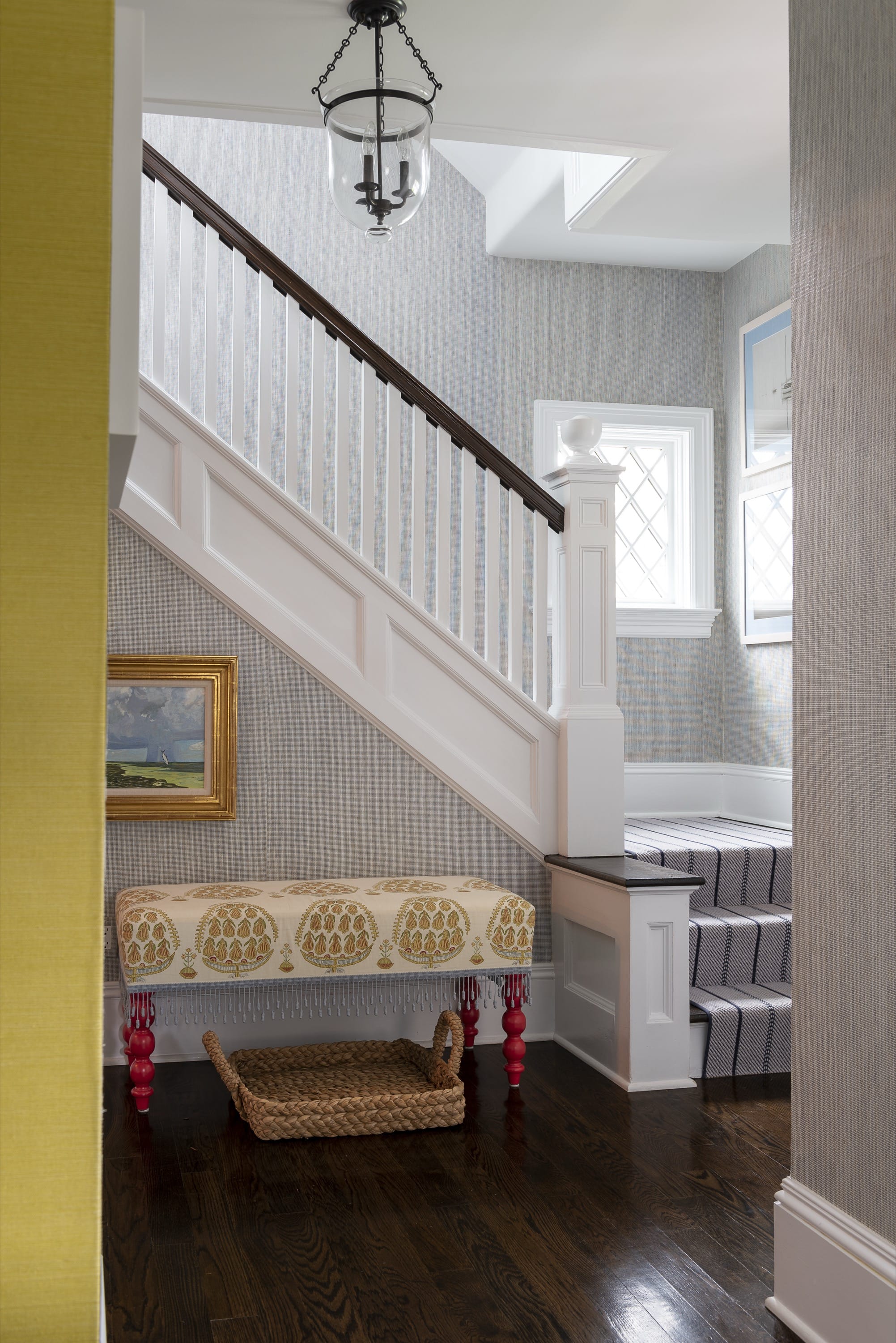 Hallway with yellow bench and staircase.