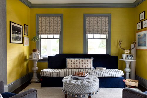 Living room with yellow walls and navy sofa.