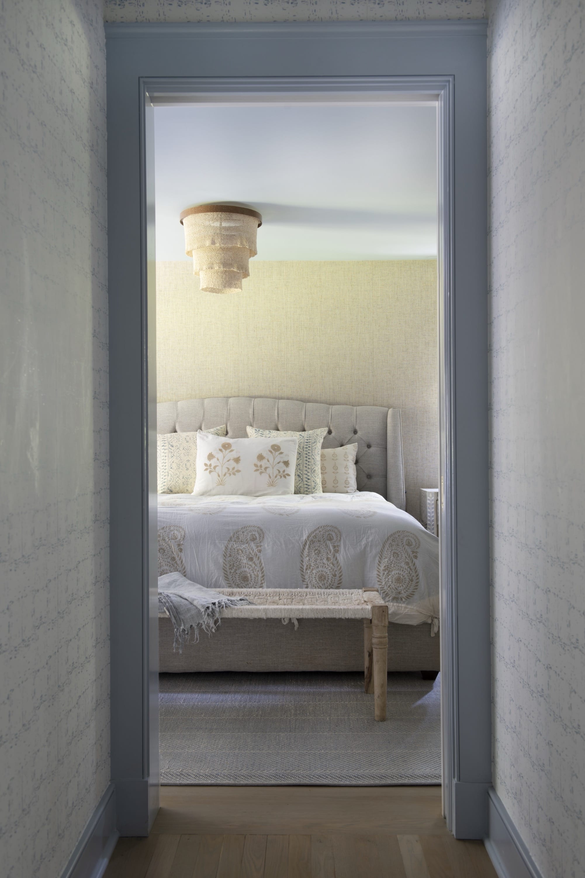 Bedroom view through hallway with white bedding.