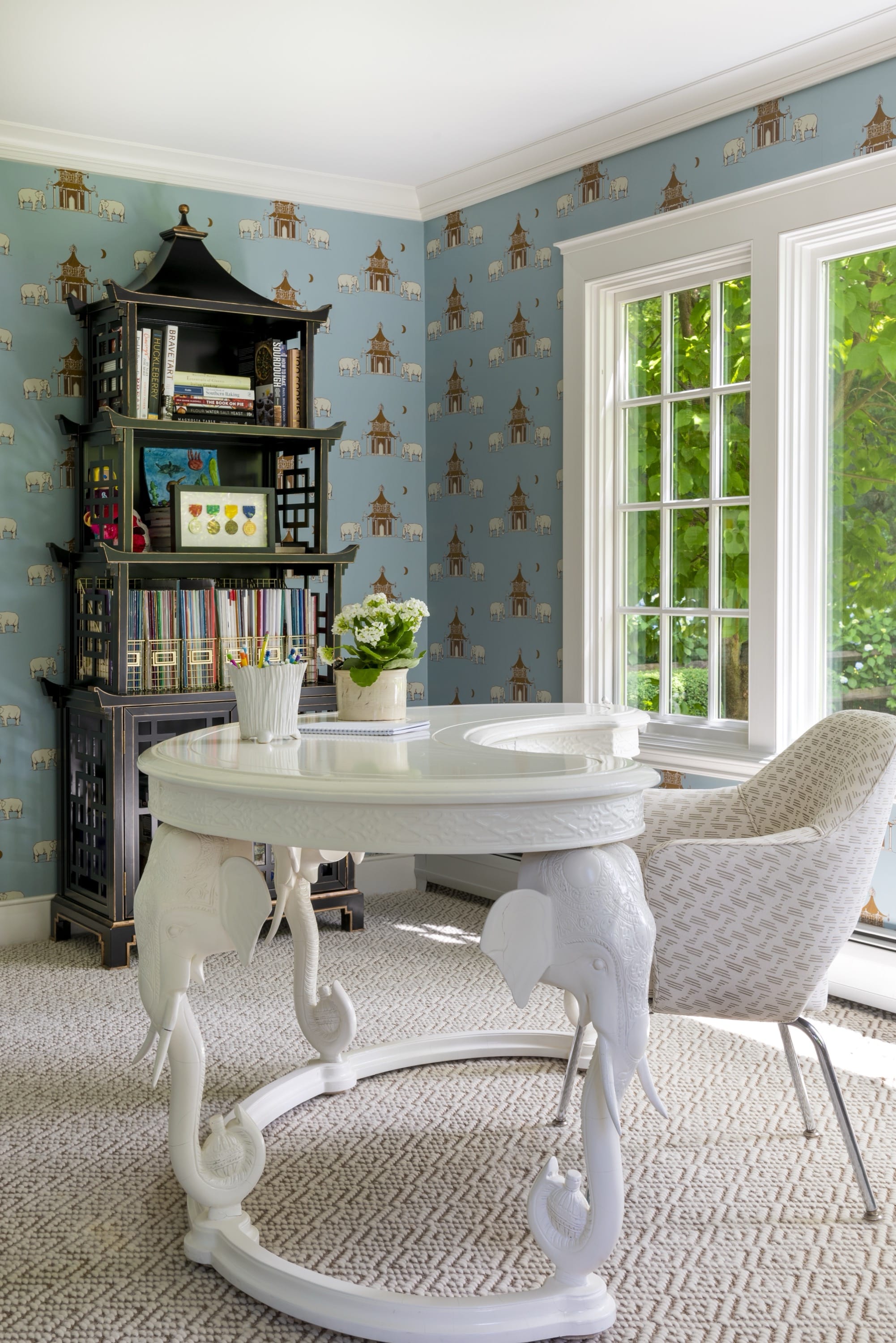 Study with round table and patterned wallpaper.
