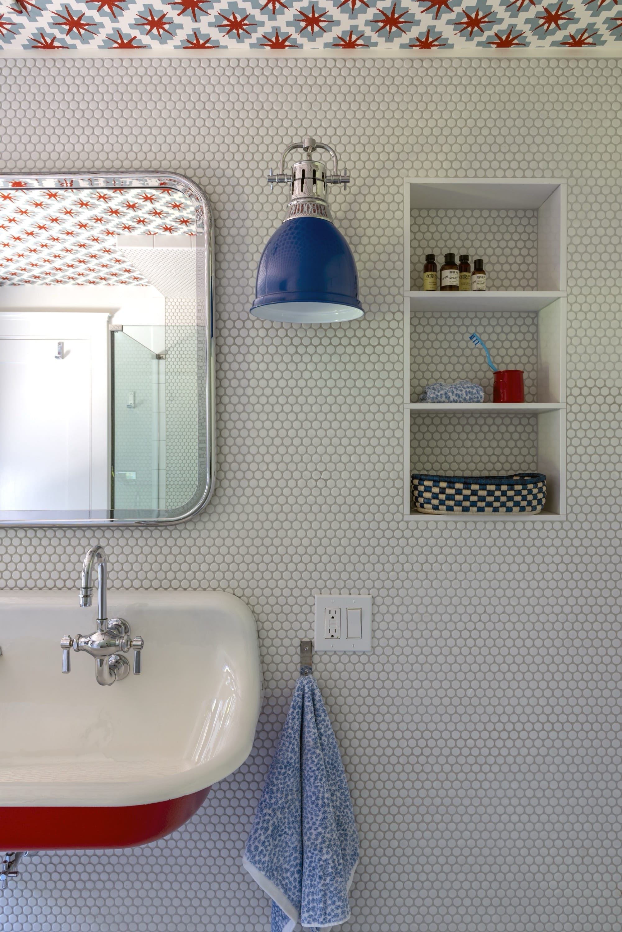 Boy’s bathroom sink with blue wall lamps.