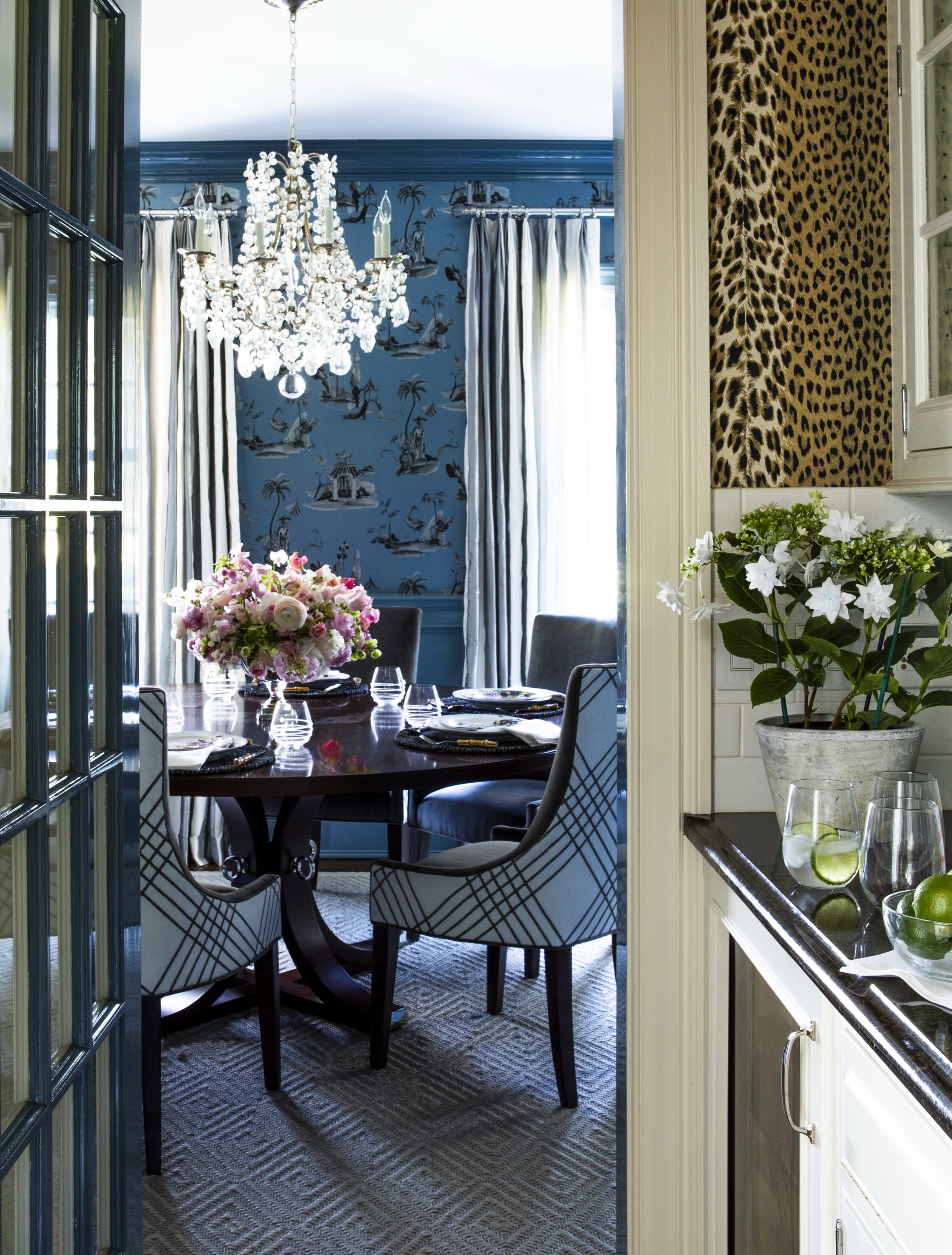 Dining room with dark blue walls and chandelier.