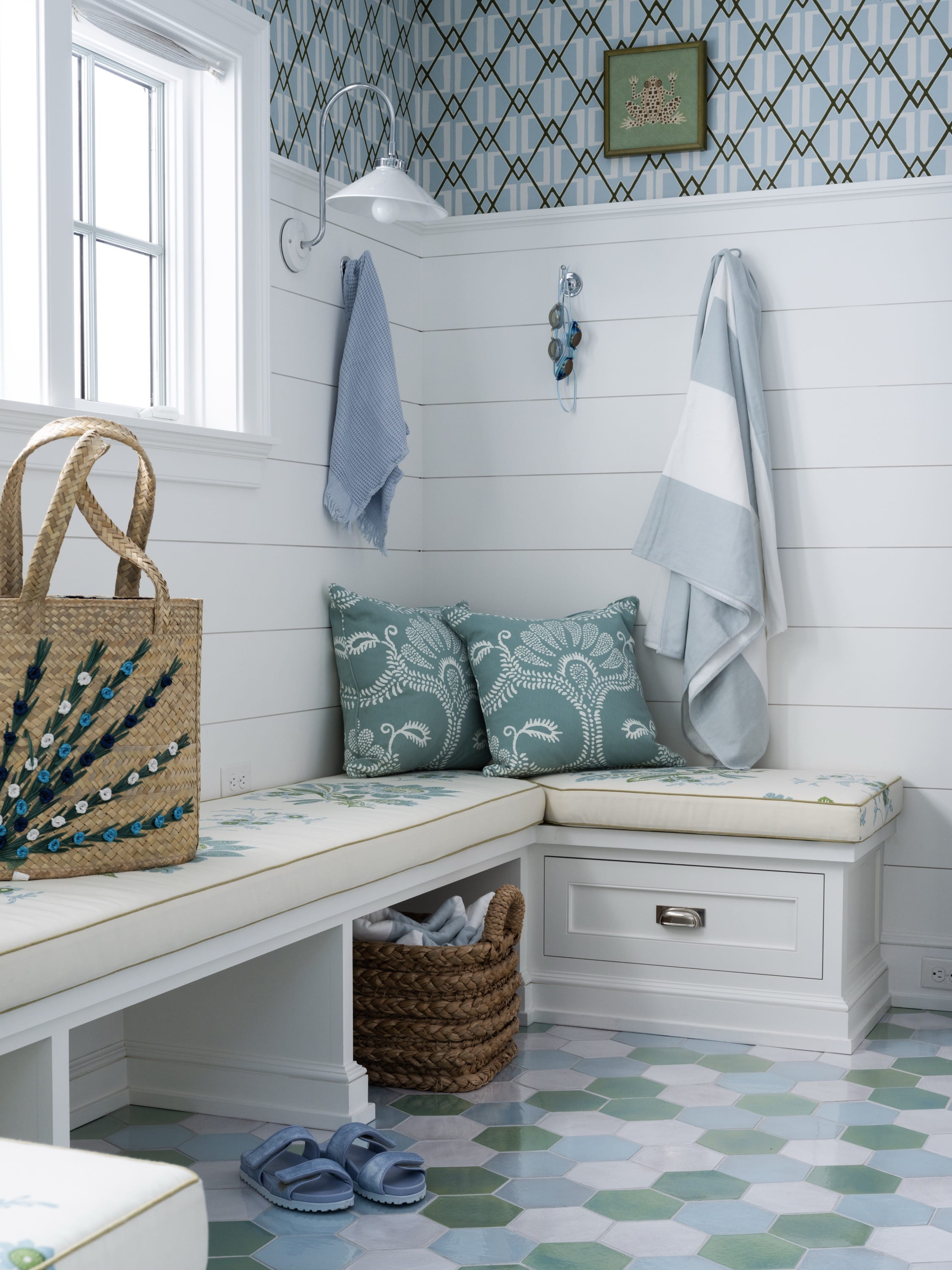 Mudroom with bench, hooks, and checkered floor.