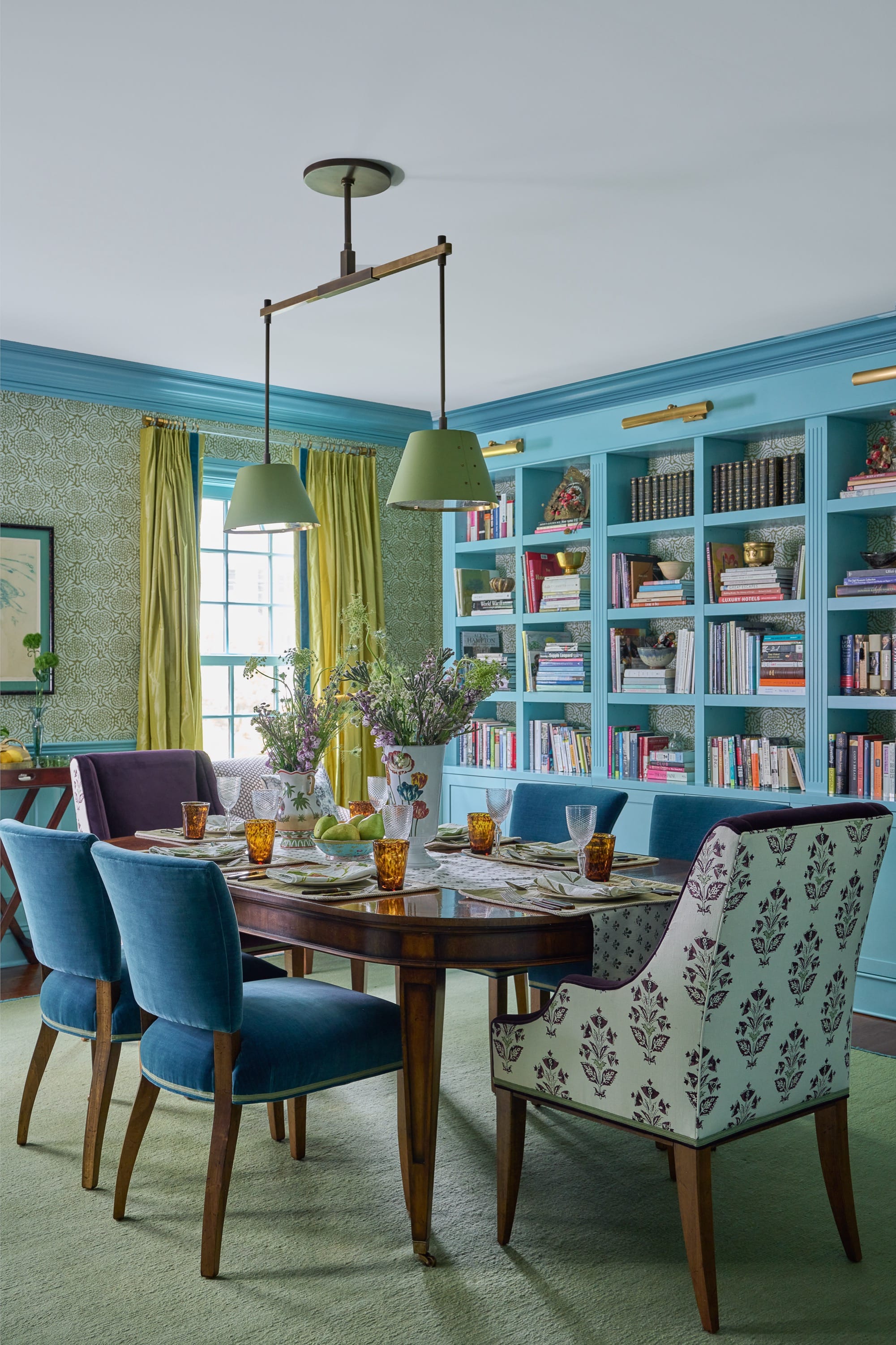 Dining room with blue chairs and built-in shelves.
