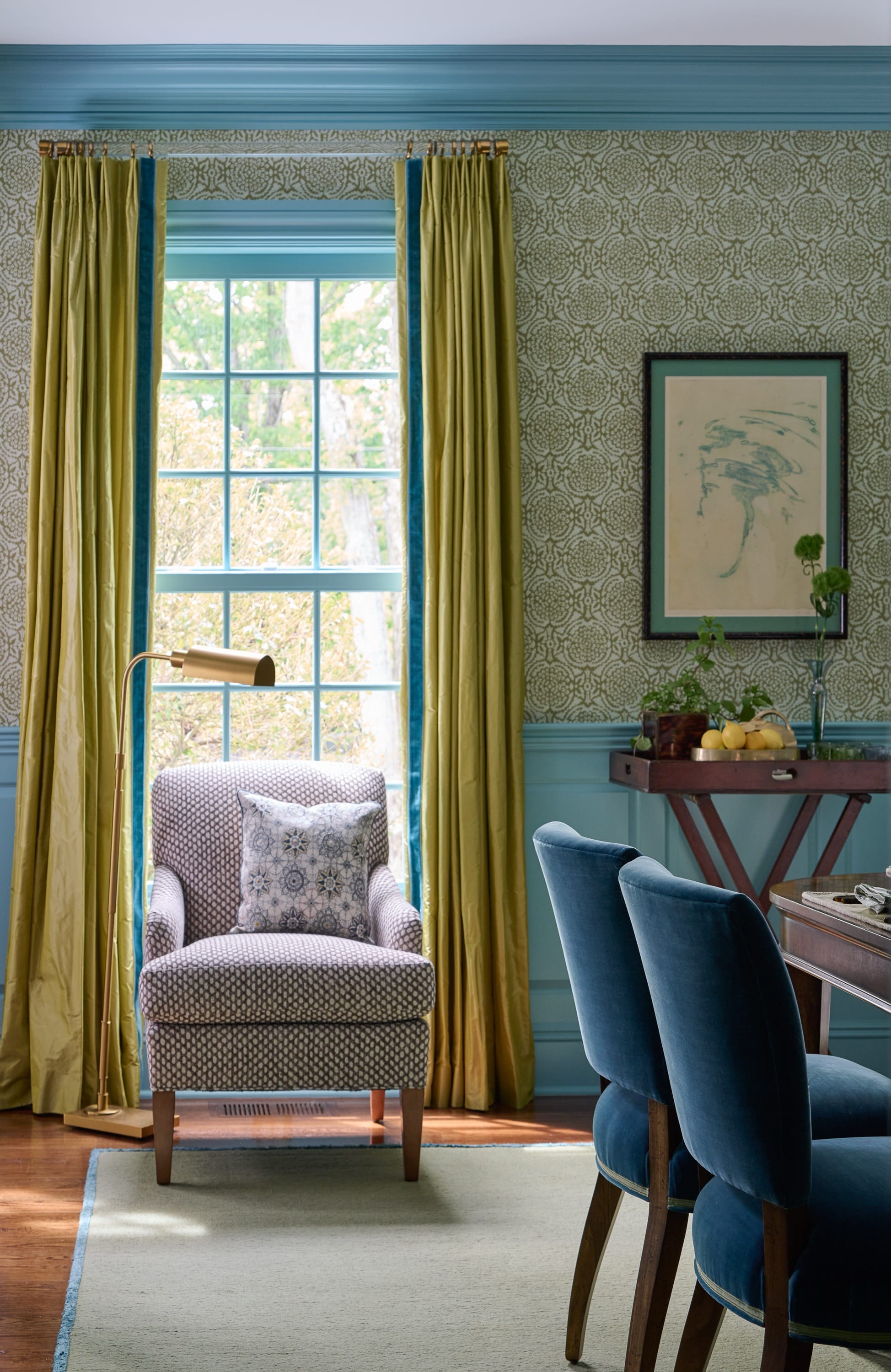 Cozy reading nook with armchair and yellow curtains.