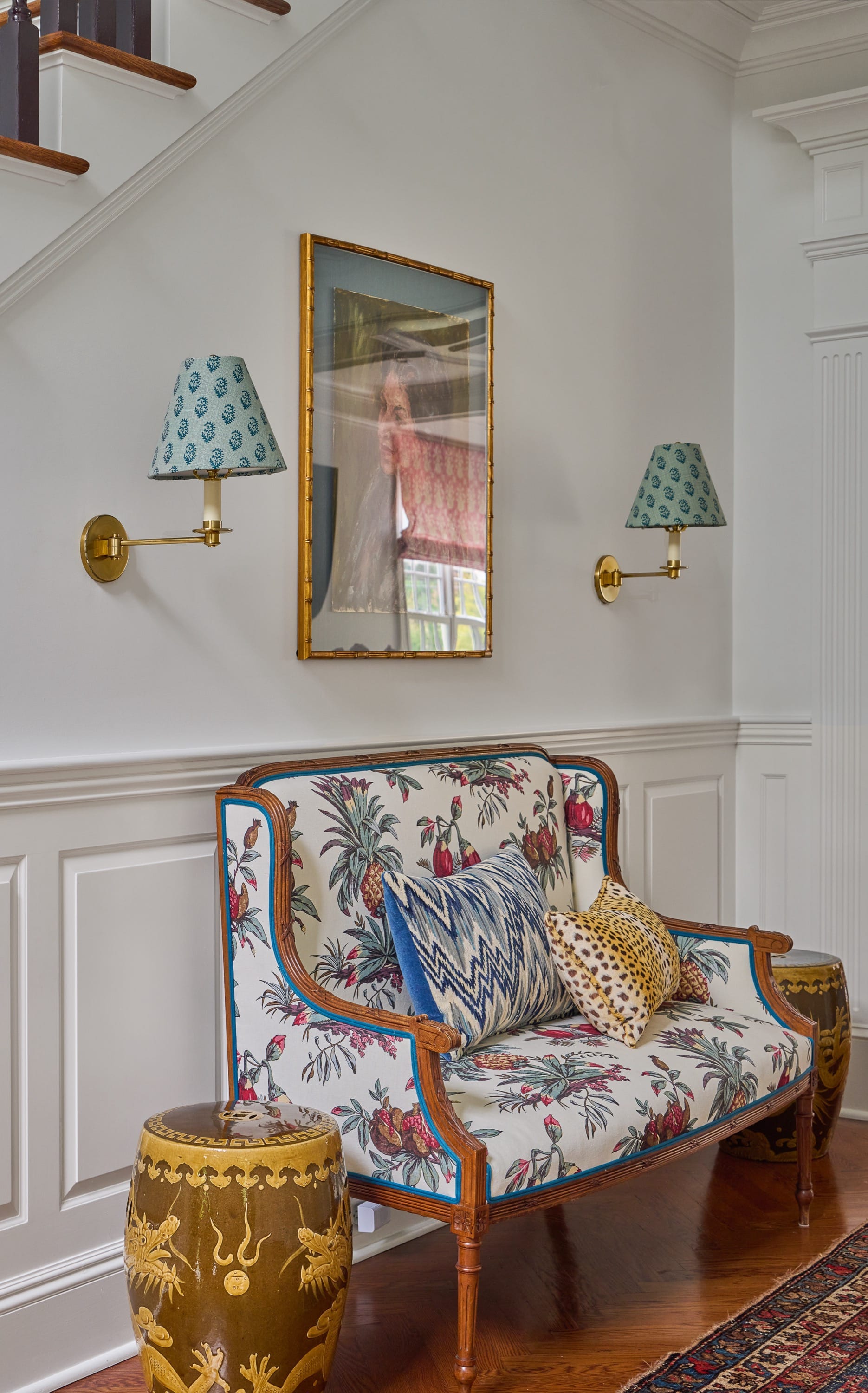 Patterned bench with pillows under wall mirror.