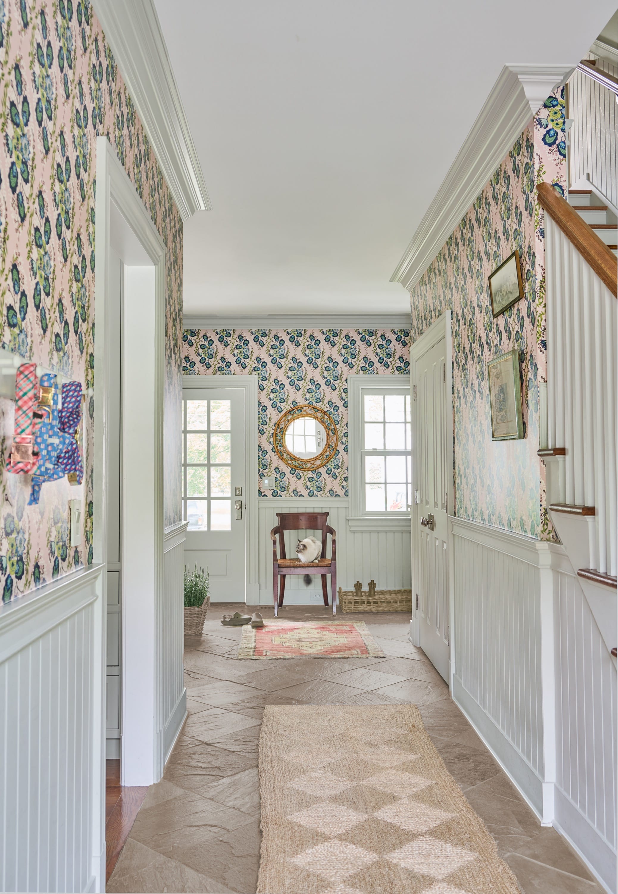Long hallway with patterned tile and staircase.