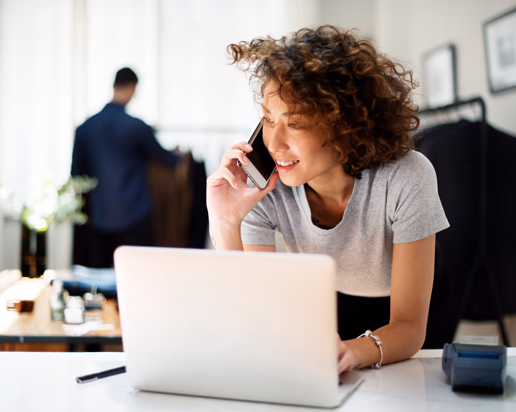 Woman talking on the phone while working on her computer.