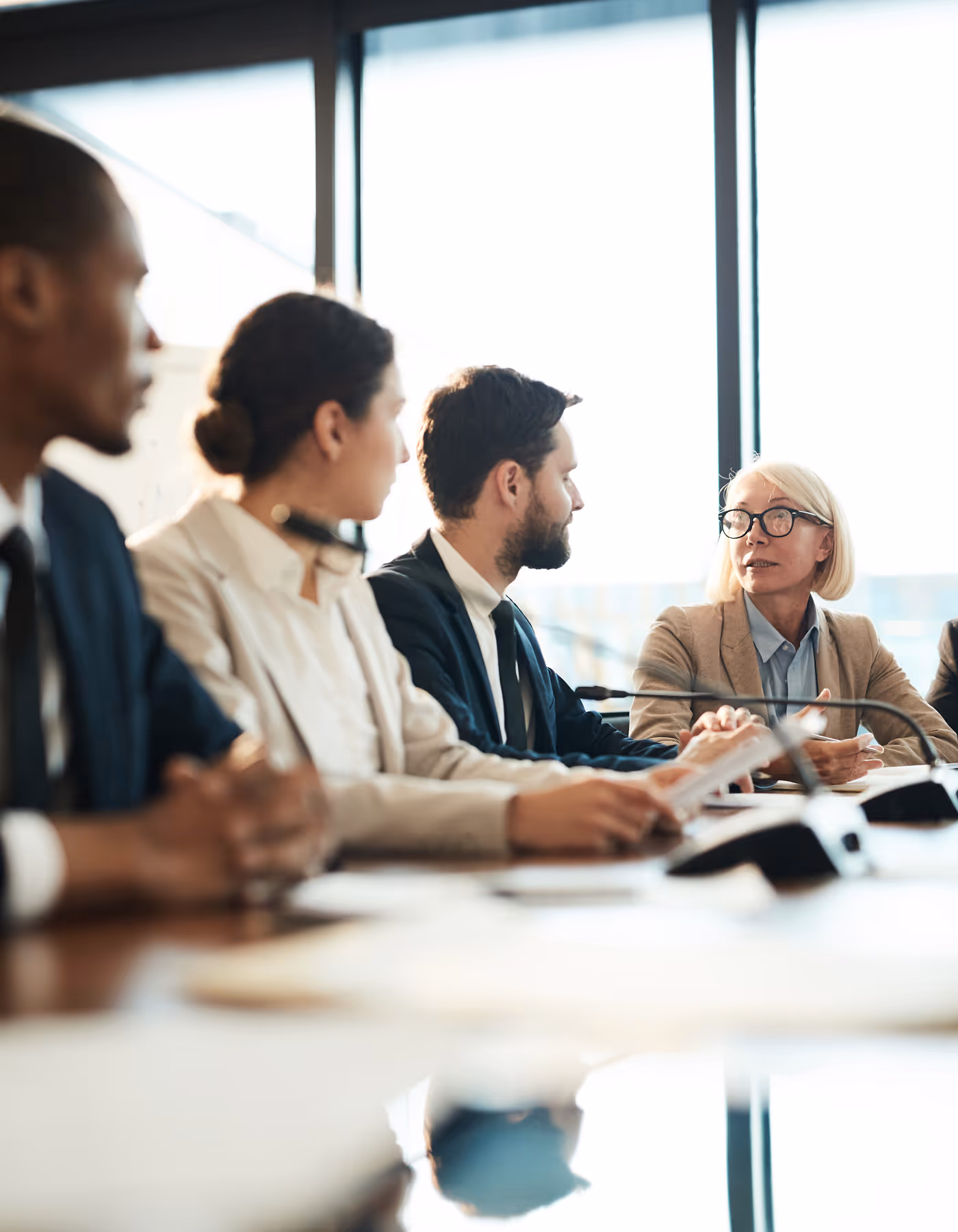 Image of a board meeting with people attentively listening to the leader.