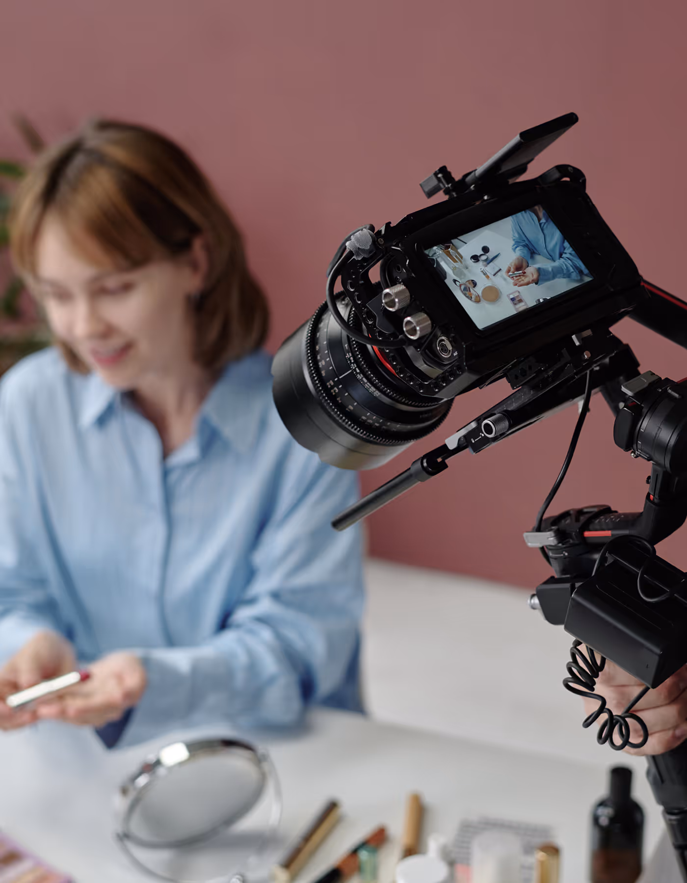 Image of camera taking a shot of a woman doing something on table.