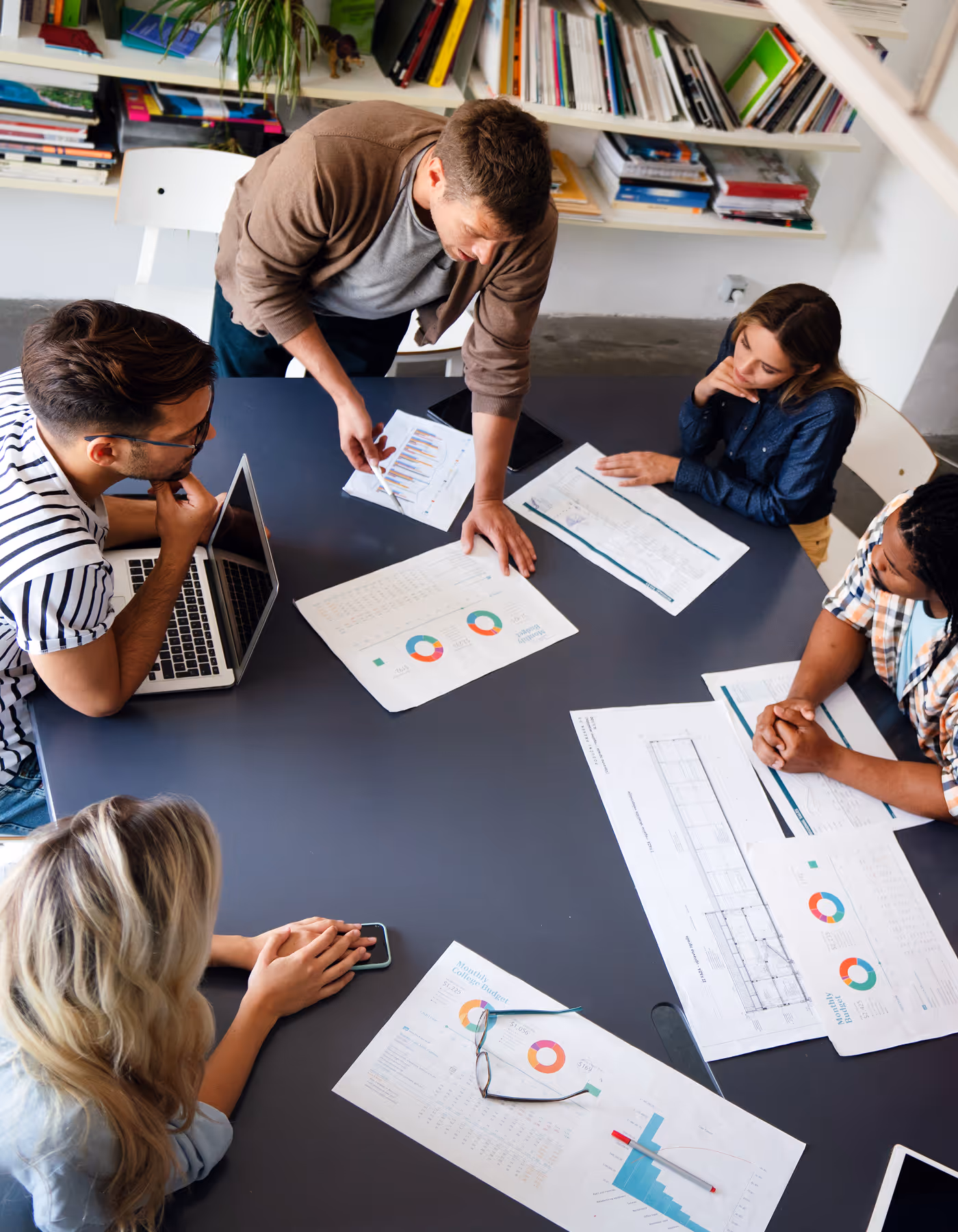 Image of a marketing team working and discussing results on a table.