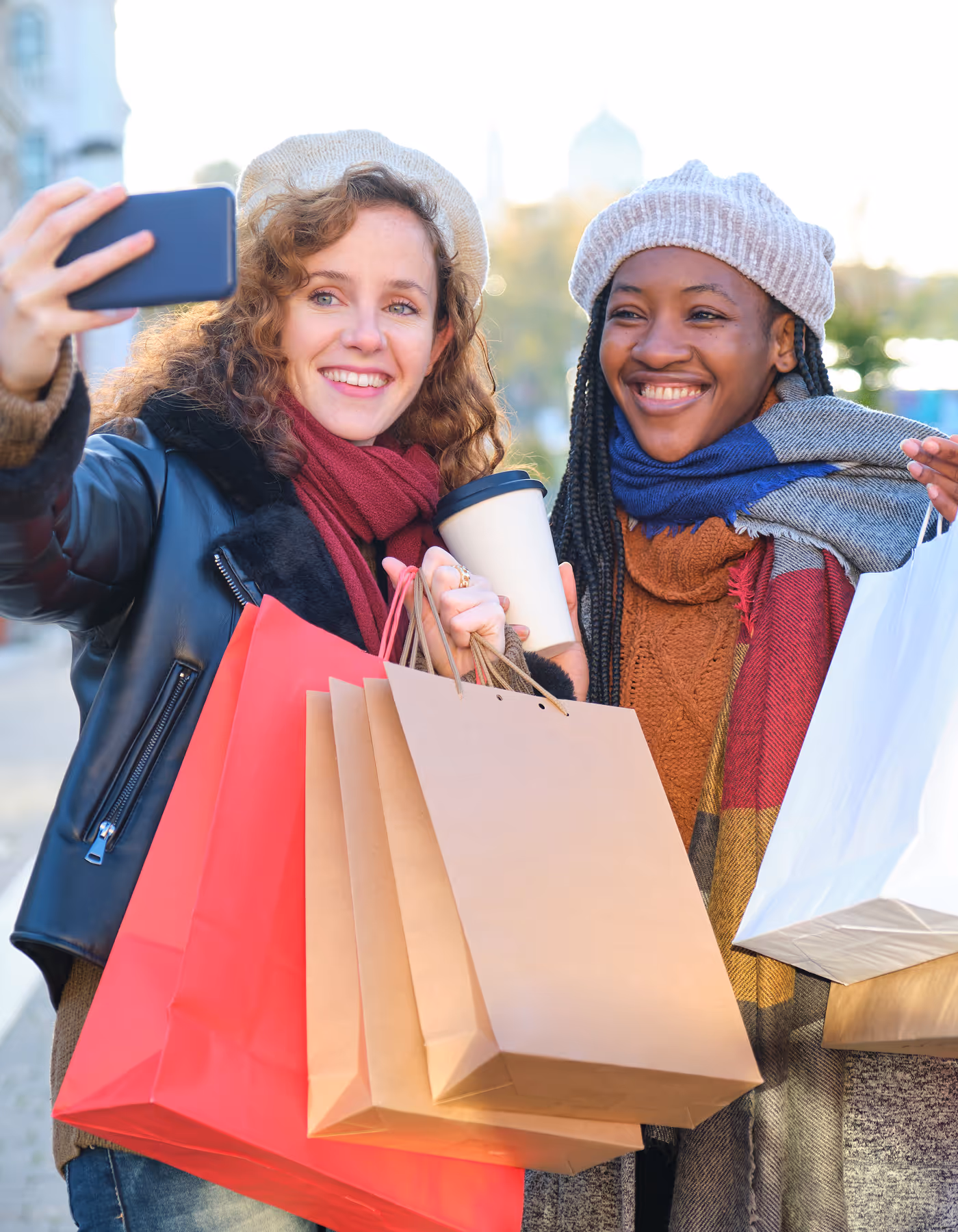 Image of two friends taking a selfie with their shopping bags.