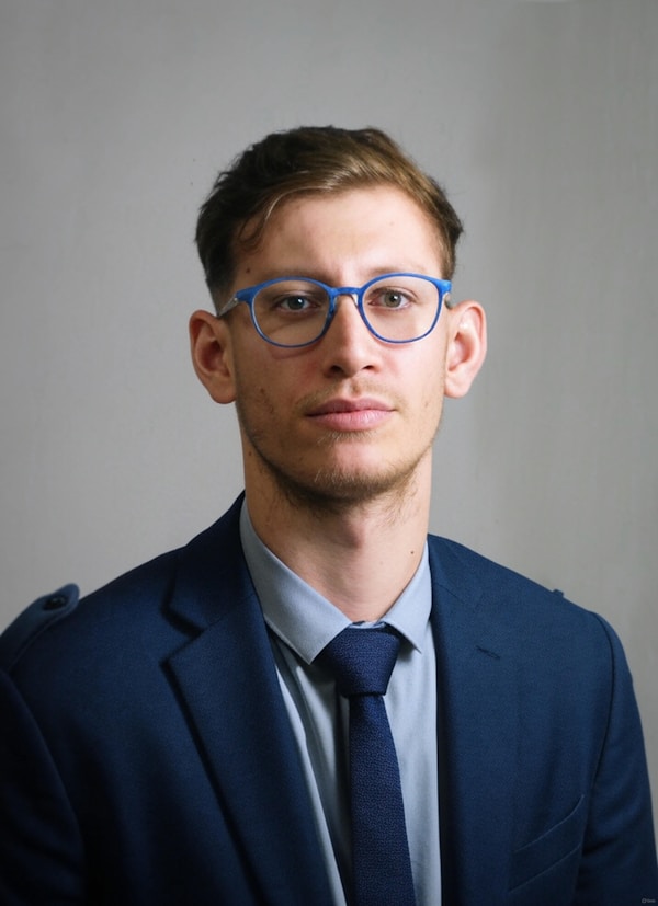 Man in suit and glasses looking at camera