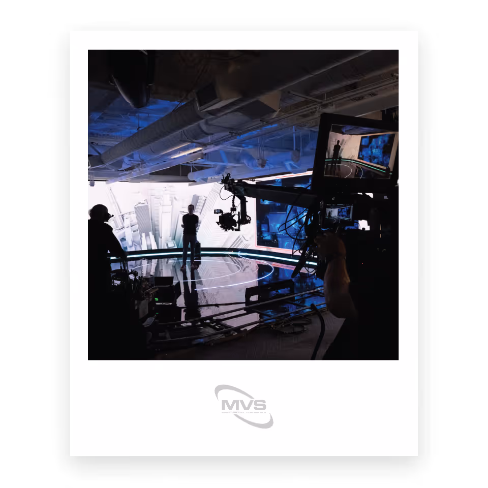 Image of a virtual event in progress with professional cameras, lighting, and a curved LED wall