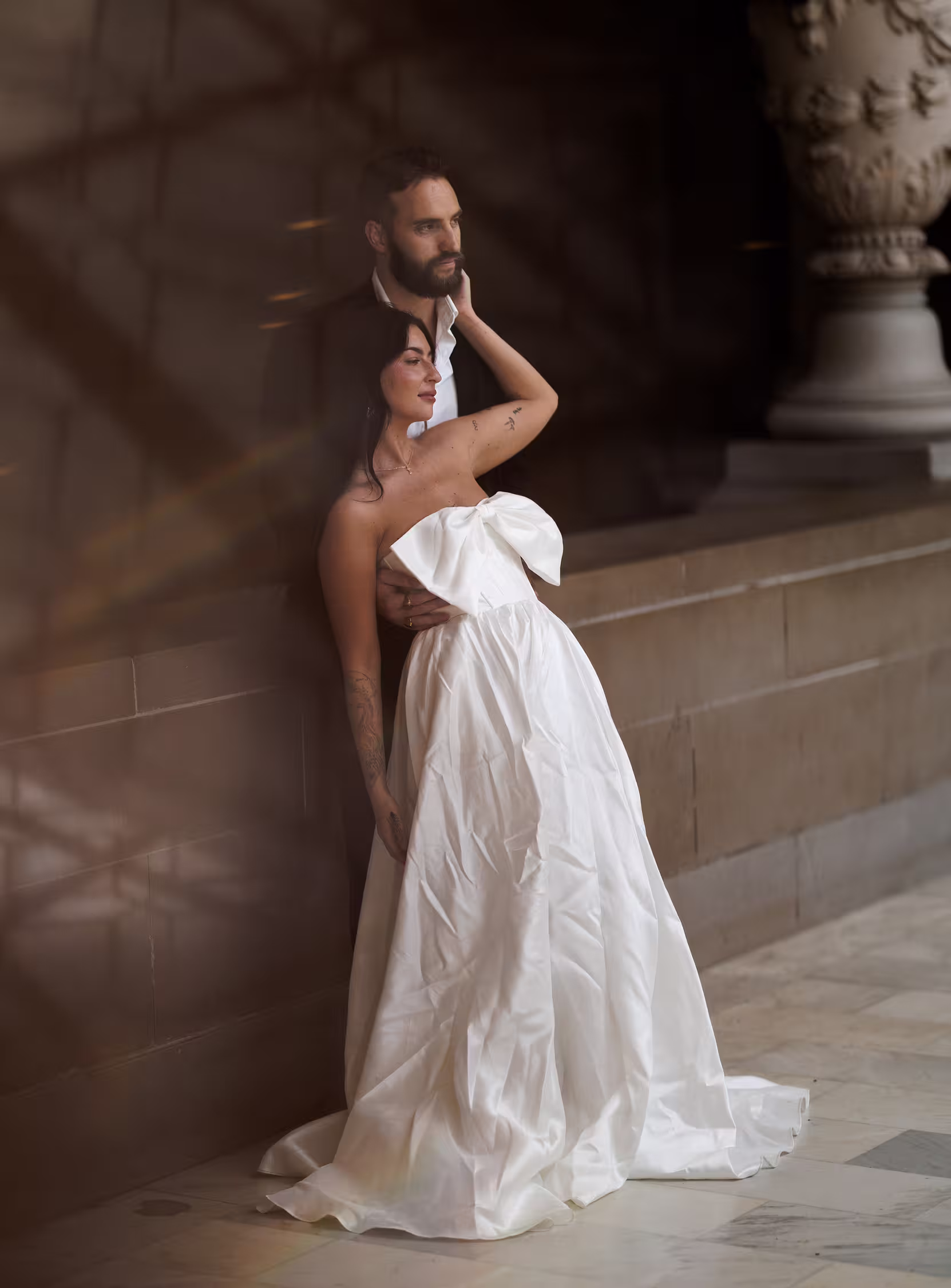 Bride and groom standing together inside San Francisco City Hall, elegant editorial wedding portrait with soft romantic light and marble architecture