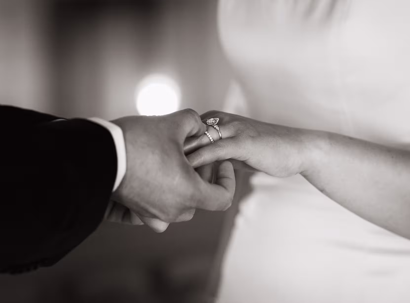 Close-up of groom placing the wedding ring on the bride’s finger during their ceremony at San Francisco City Hall, elegant black and white moment with soft light