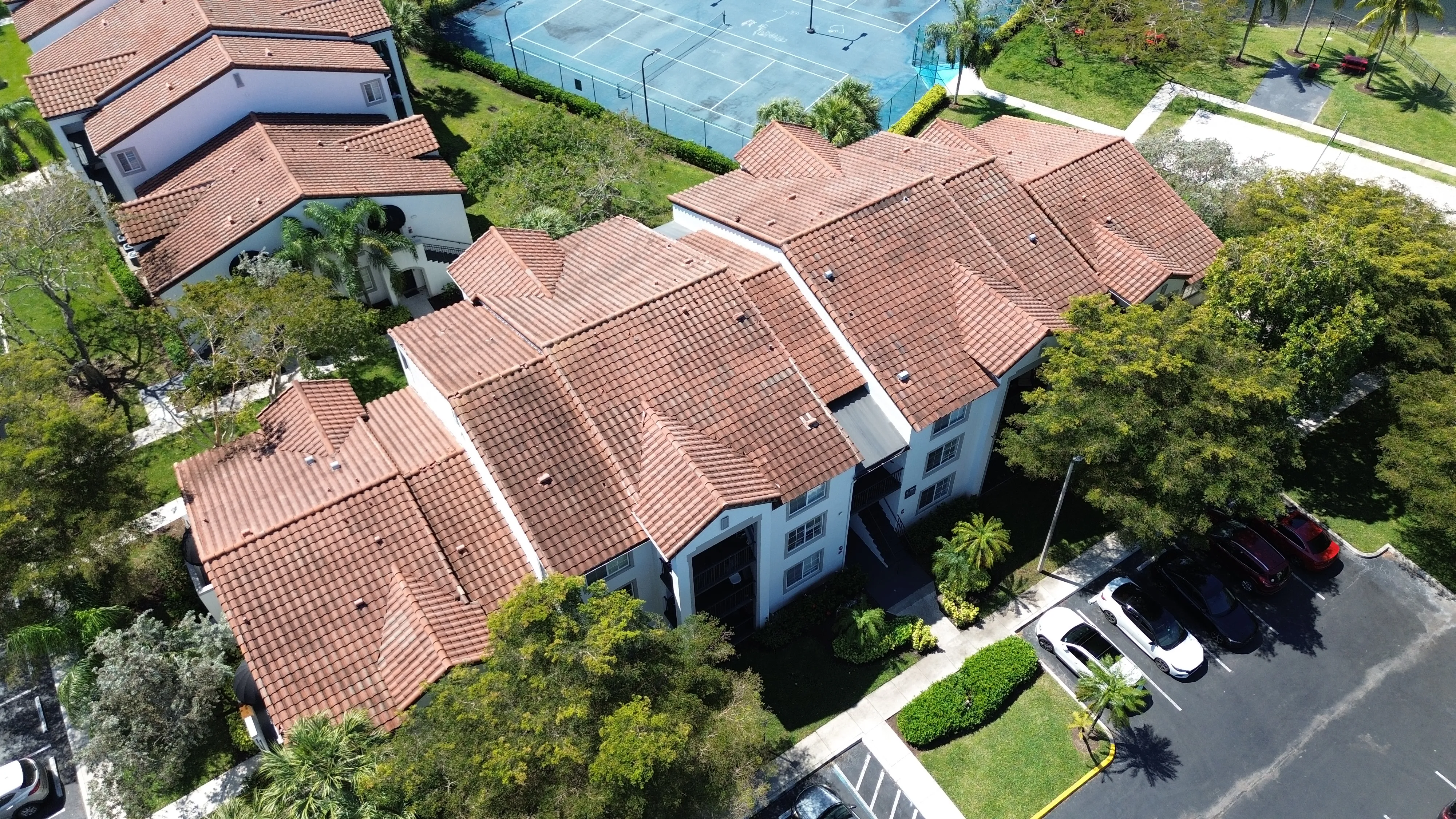 Aerial view of The Enclave Apartments at Waterways tile roofs and tennis courts in Deerfield Beach