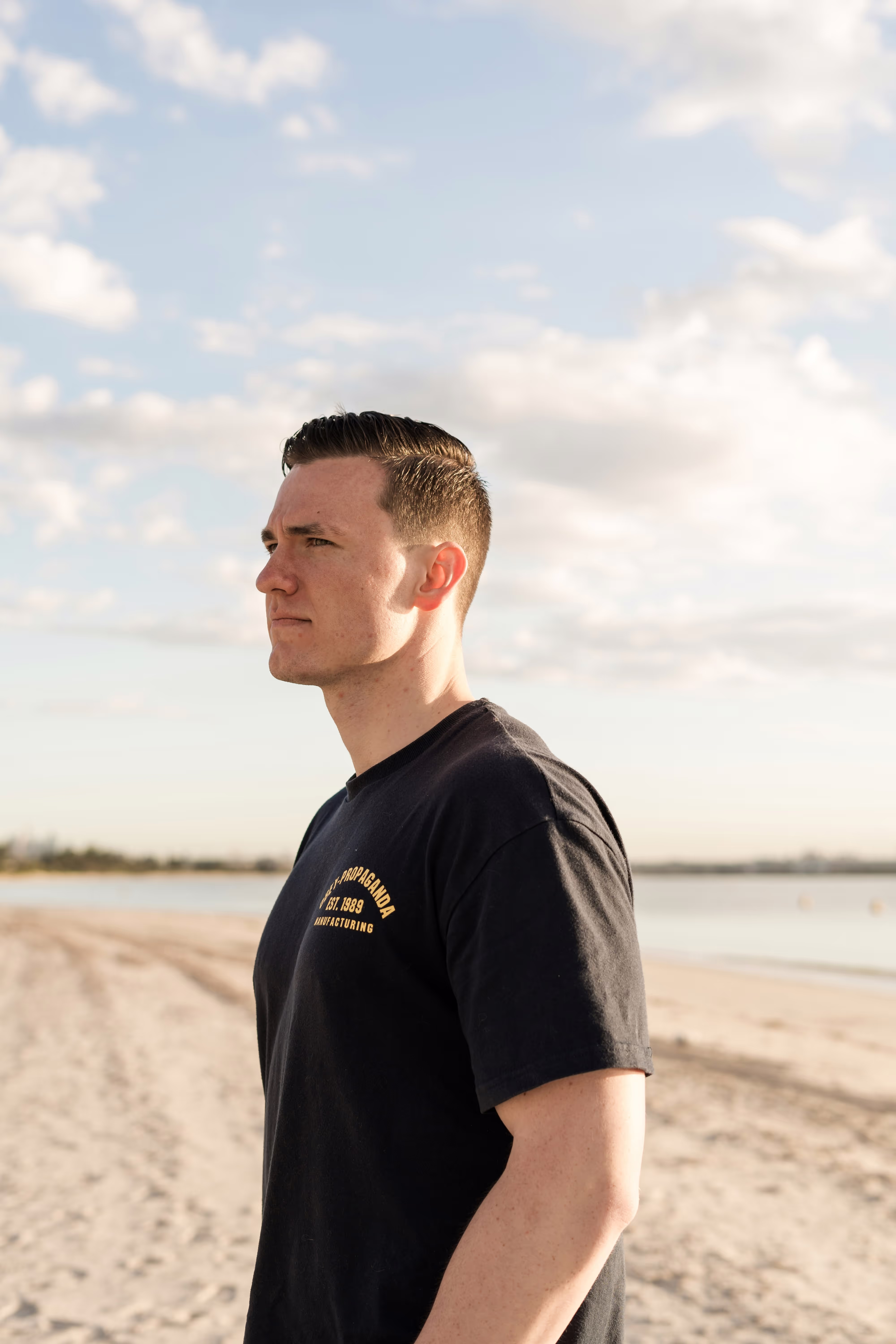 A man standing on a beach next to the ocean