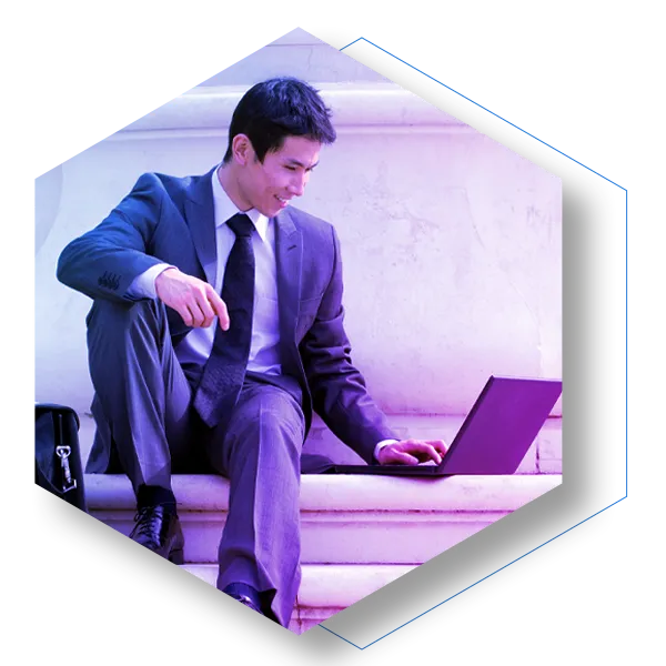 Man in suit sitting on steps to building working on a laptop