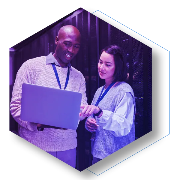 Infrastructure team looking at laptop in server room from a laptop
