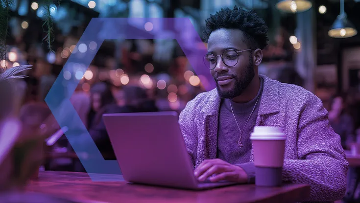 young man sitting at cafe using laptop computer typing keyboard online outside