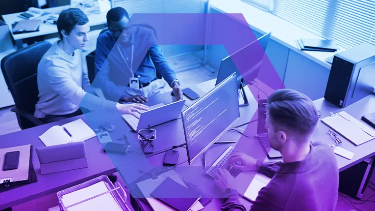 High angle shot of busy IT professionals sitting at office desks while developing cybersecurity protocols