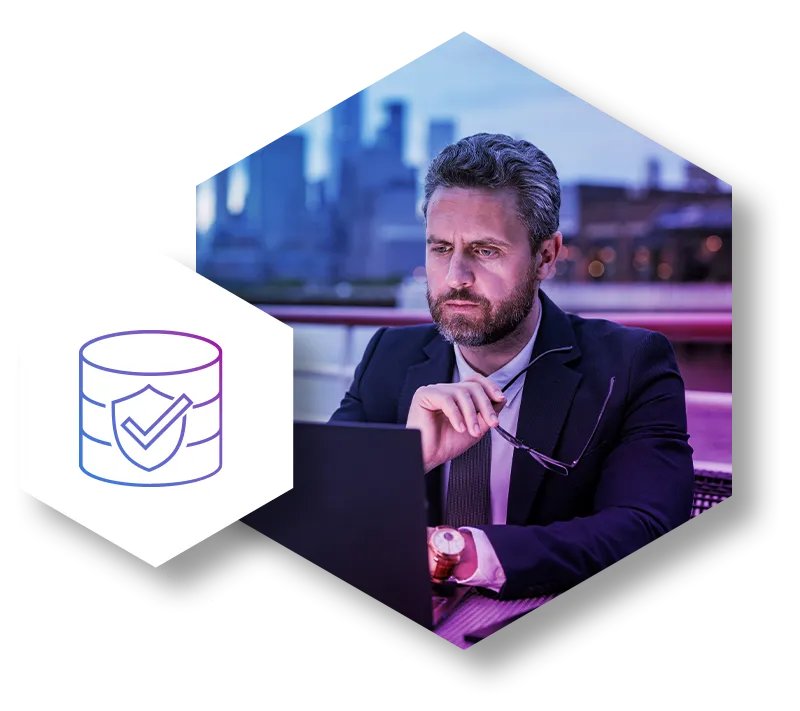 Data security concept: Man working on laptop with database shield icon.