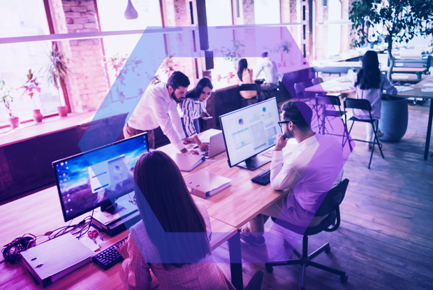 A team of professionals collaborating in a modern office, illustrating a use case for replacing VDI and DaaS to reduce costs and improve user experience.