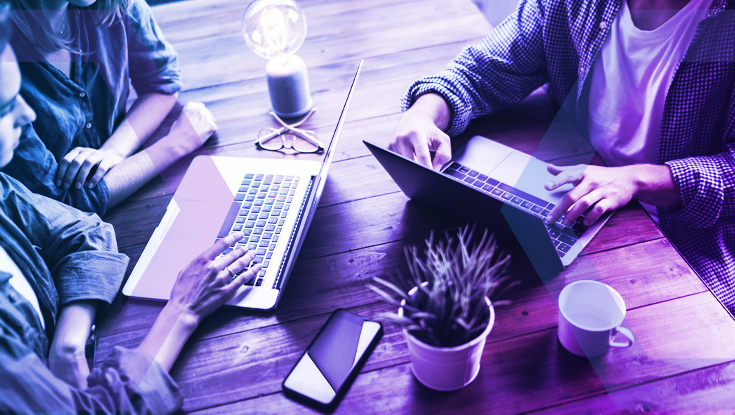 A team works securely on laptops, representing how Menlo Cloud's Network Separation provides a protective barrier for enterprise applications.