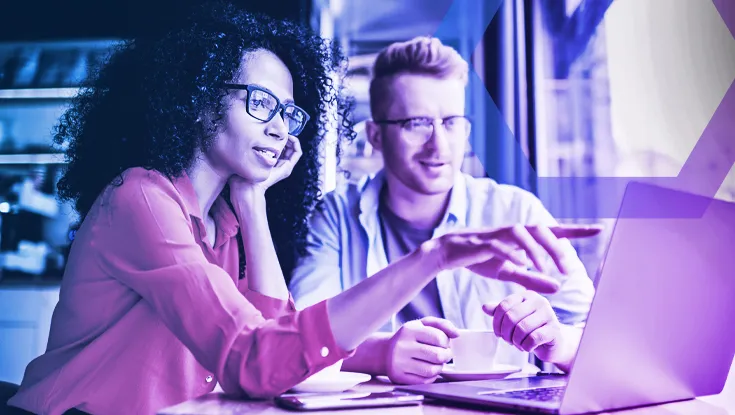 Two professionals collaborate on a laptop, representing the secure application access enabled by Zero-Trust Network Separation. The image symbolizes how guaranteeing application-by-application access eliminates the external attack surface and lateral movement risk.