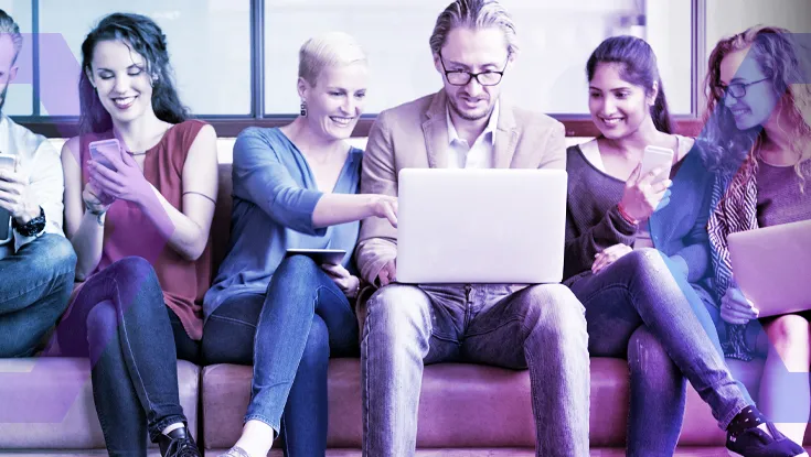 An image illustrating the 'Any user, Any Device' concept, showing a diverse team working together on a laptop and mobile phones.