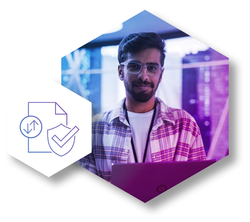 A tech professional, a young man with glasses and a plaid shirt, works on his laptop, representing robust file security. He is framed by a purple geometric design and a hexagonal icon symbolizing secure file transfer and data protection against cyber threats.