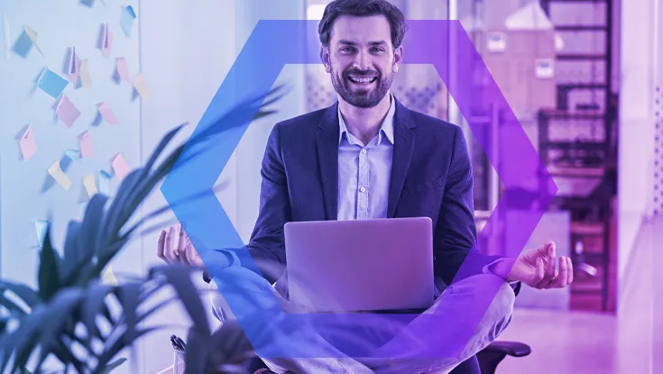 A smiling businessman sits cross-legged in a meditation pose on his office chair, holding a laptop. This symbolizes the peace of mind and stress-free productivity enabled by secure data and file protection, all framed by a blue and purple geometric overlay.