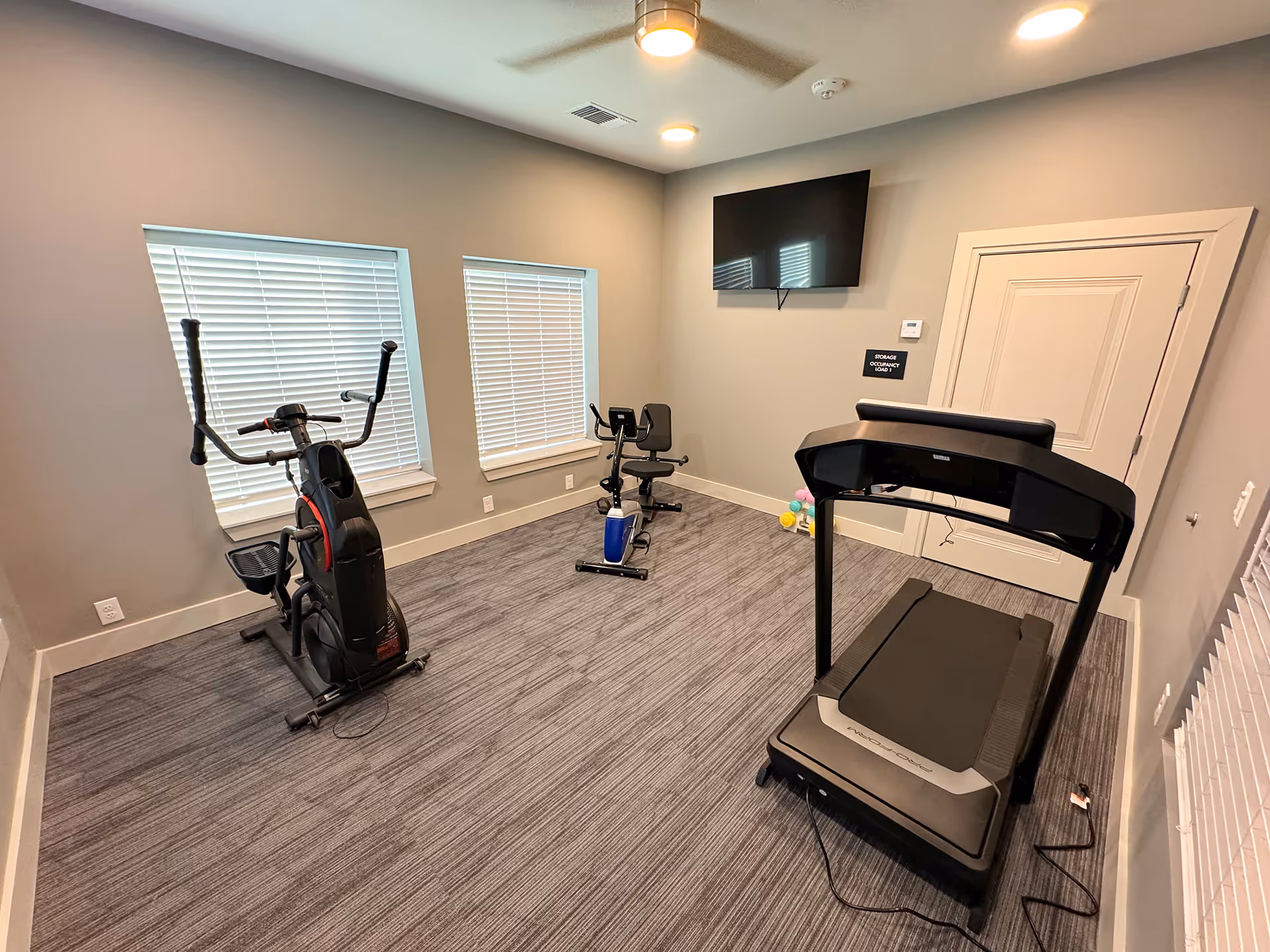 fitness center with treadmill and stationary bike