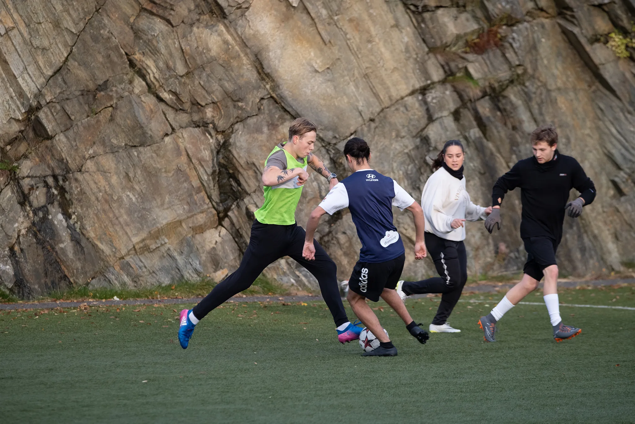 elever spiller fotball på gressplen