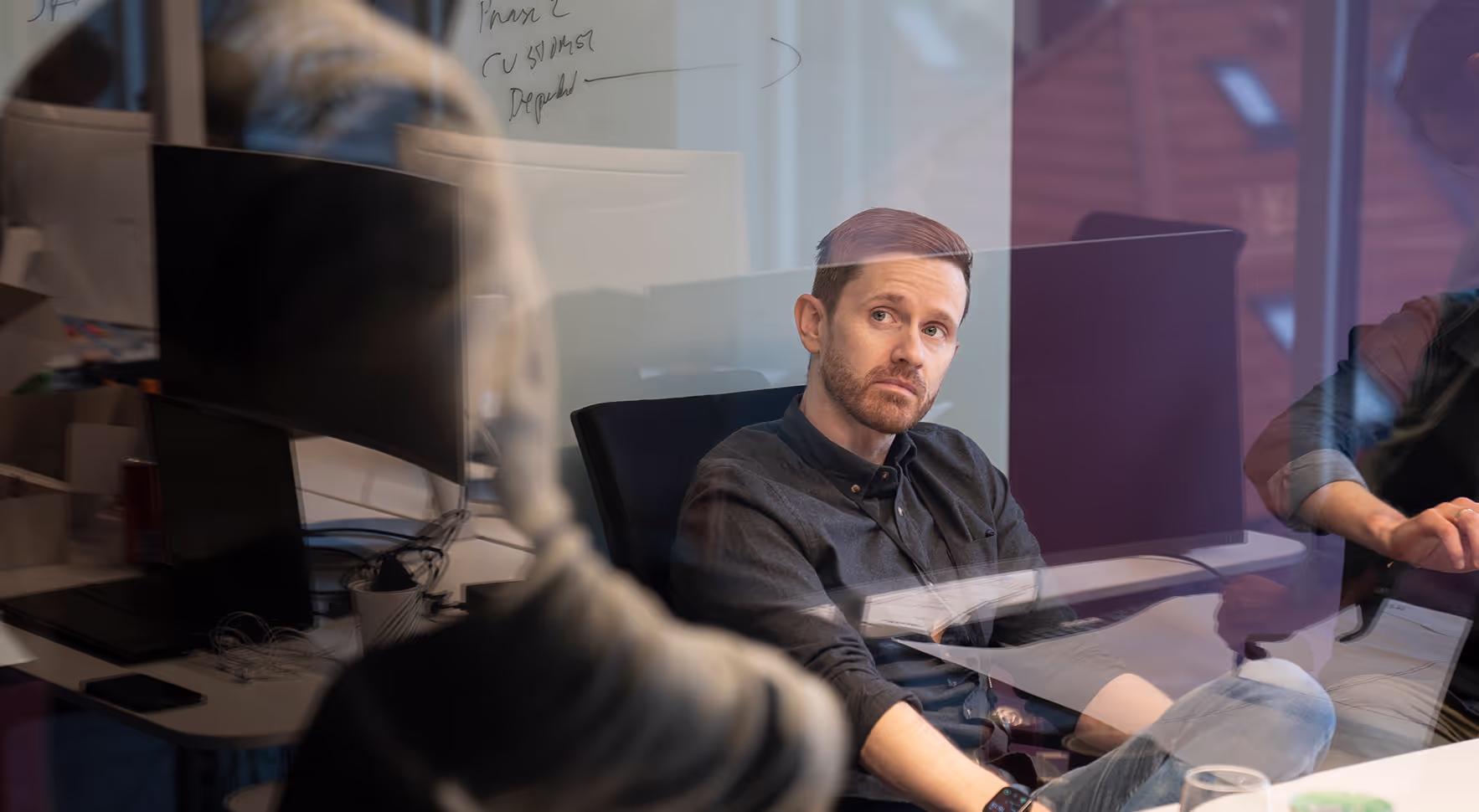 A Casi engineer at work behind a glass wall covered in notes