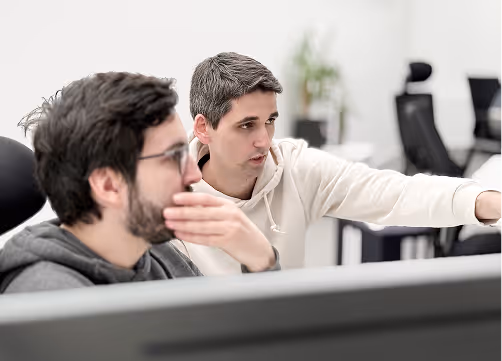 Two software developers are discussing and optimizing their code.