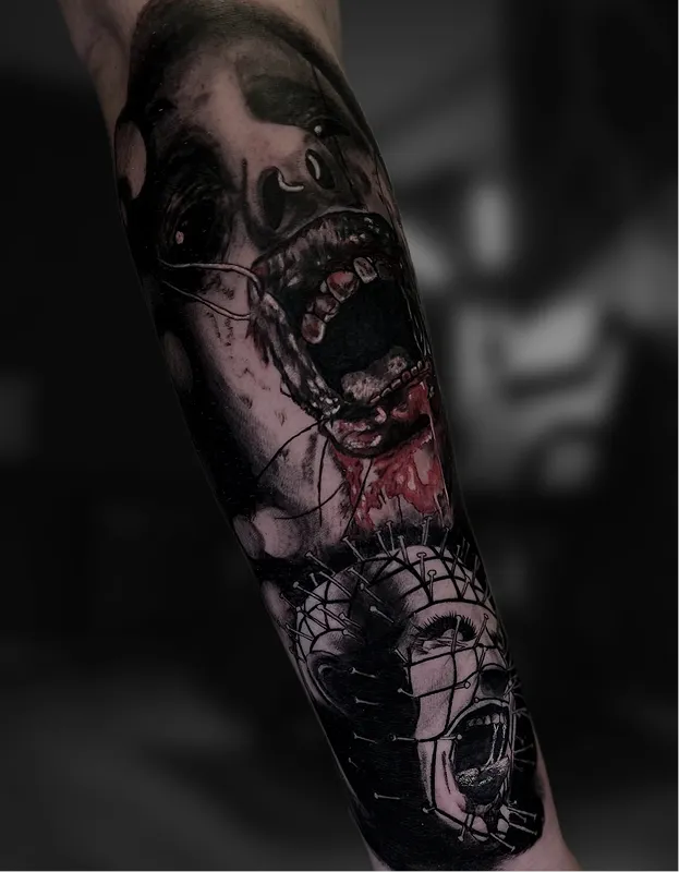 Black and grey tattoo of a realistic eye above a skull with a tree and hanging figures on the arm.