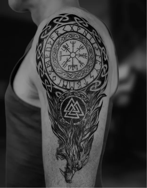 Black and grey tattoo of a realistic eye above a skull with a tree and hanging figures on the arm.