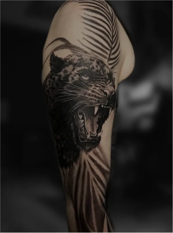 Black and grey tattoo of a realistic eye above a skull with a tree and hanging figures on the arm.