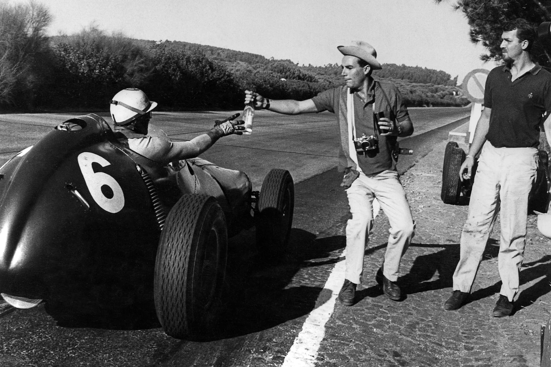 Harry Schell attrapant une bouteille d’eau au Portugal en 1959