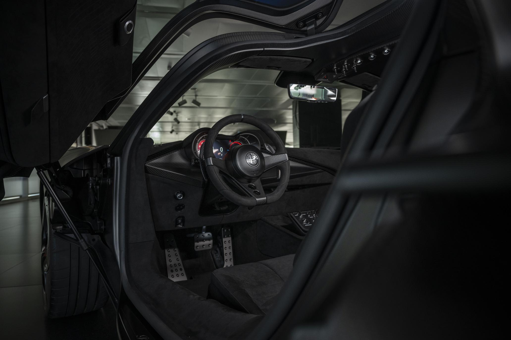 Habitacle de l’Alfa Romeo 33 Stradale Perla Nera vu à travers la porte ouverte