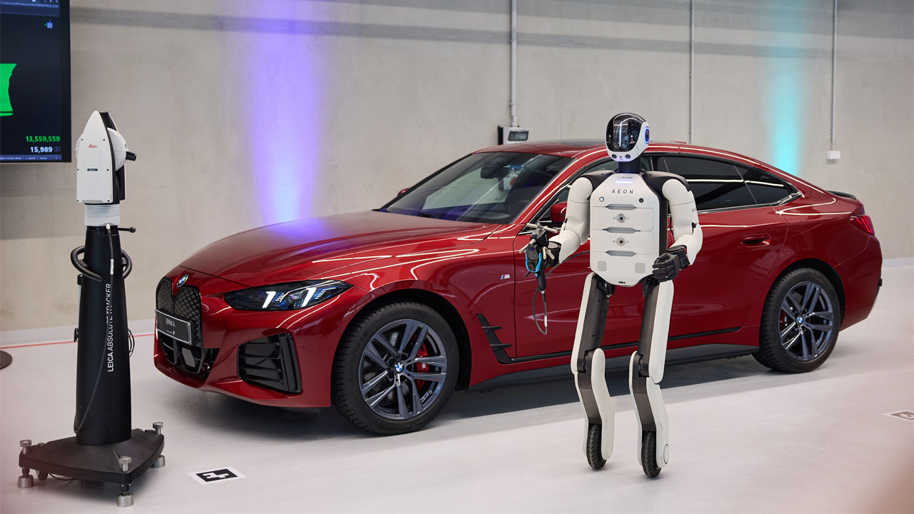 Le robot AEON et une employée BMW manipulant un composant à Leipzig
