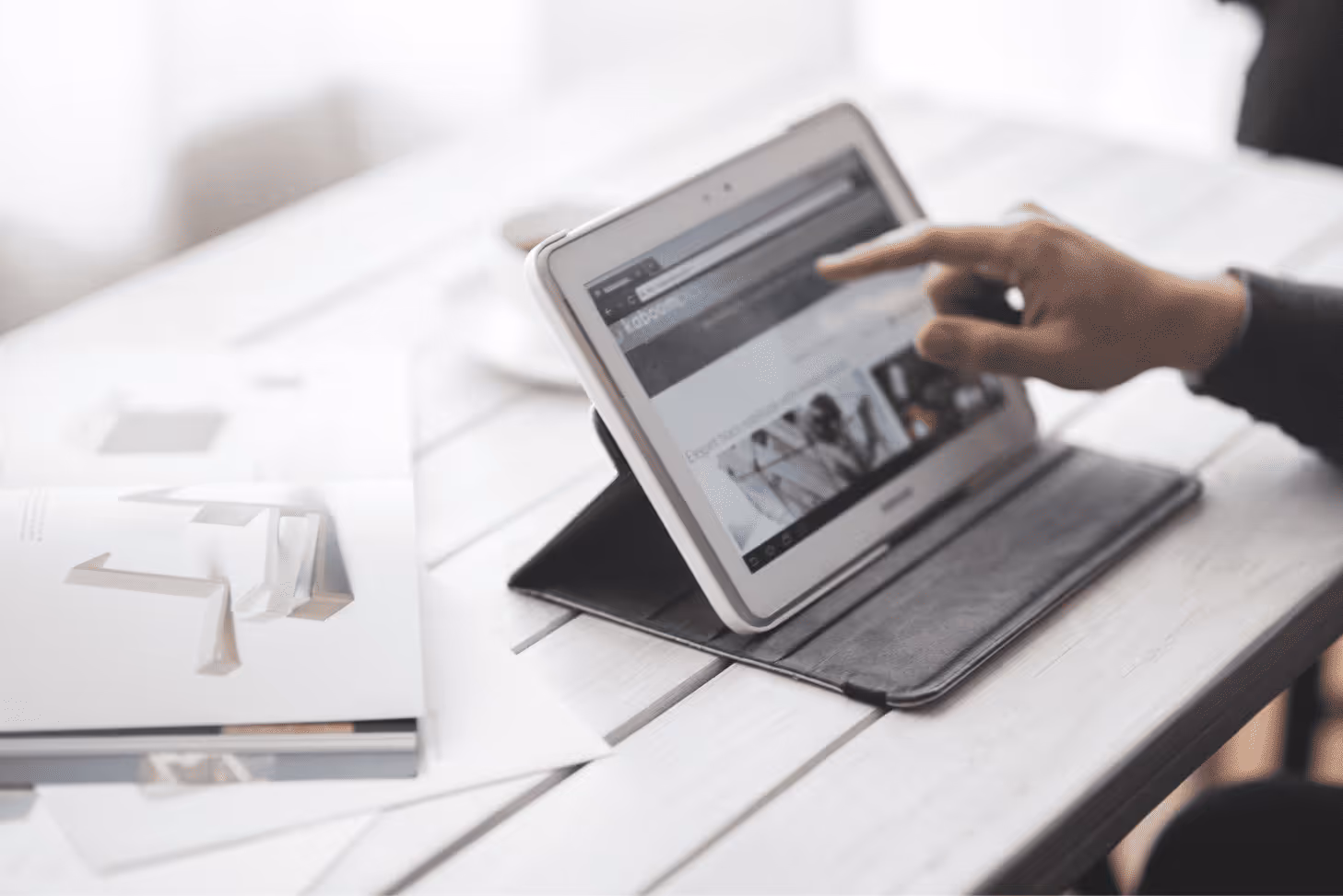 A person is holding a tablet with a website open.