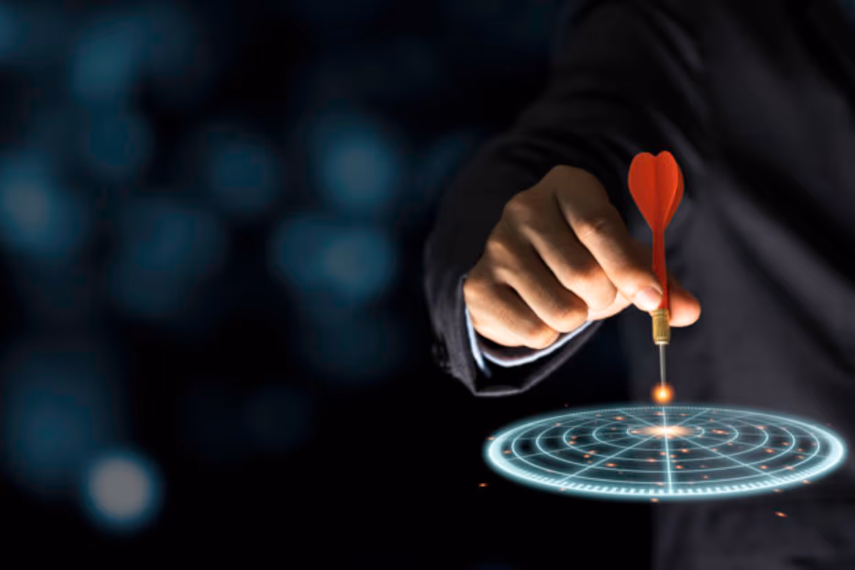 A man in a suit is holding a red arrow pointing at a target.