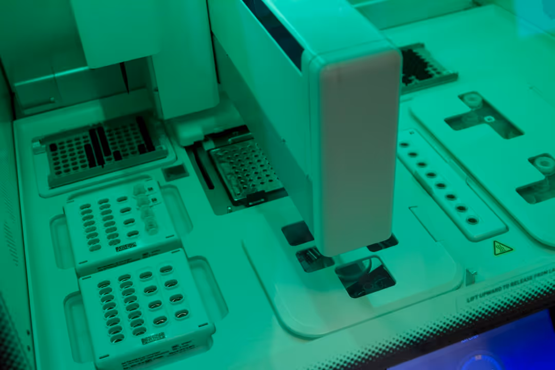 A white machine with a green light on it.