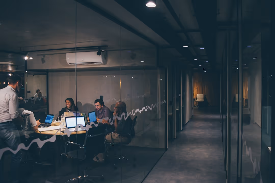 A group of people sitting in front of a glass wall.