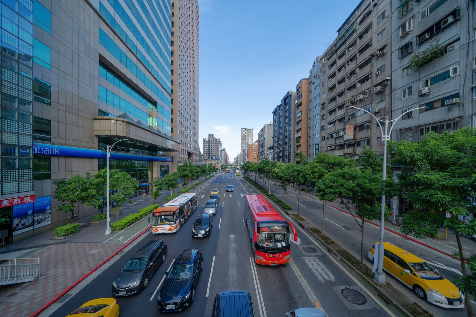 A busy city street with cars, buses, and pedestrians.