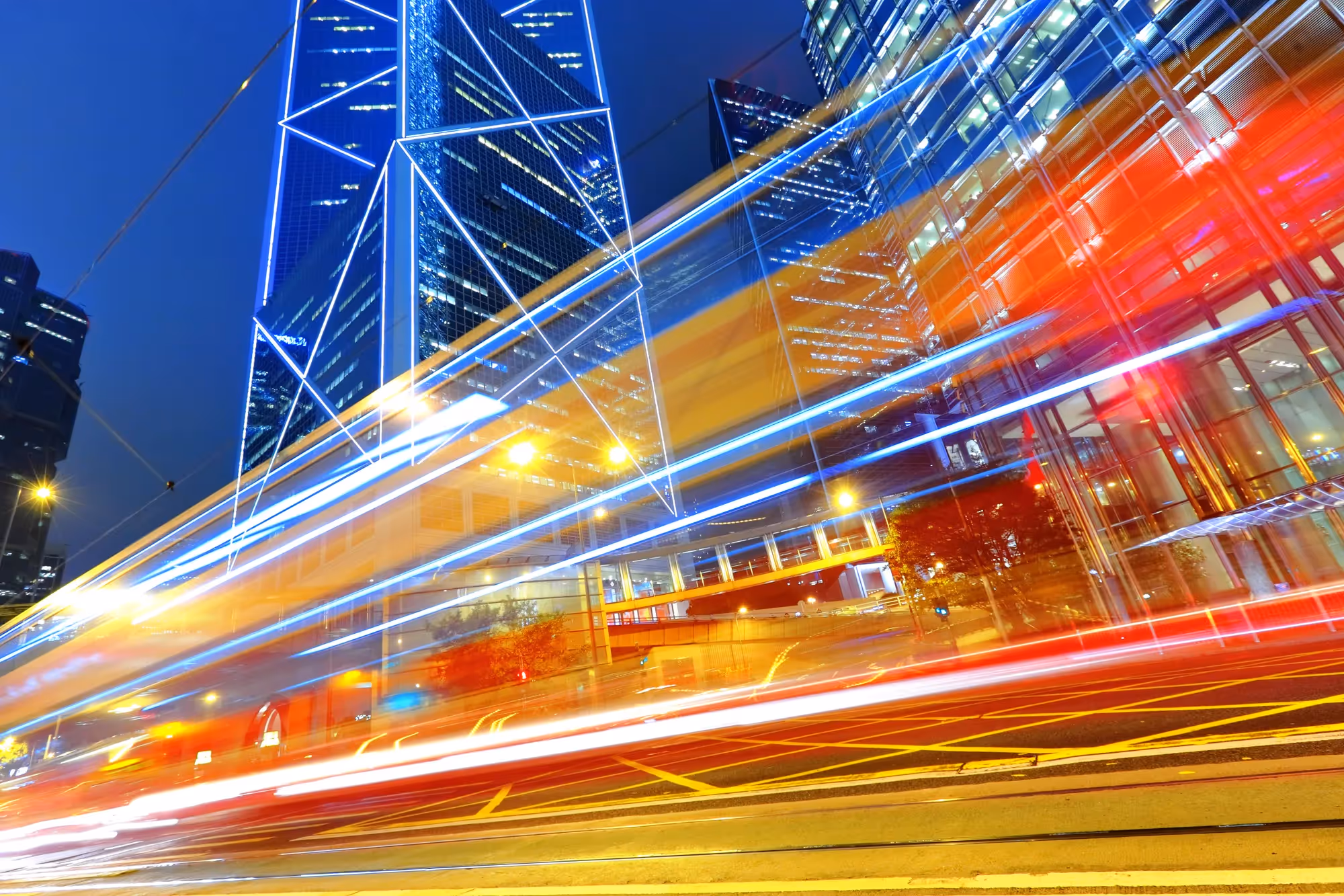 A blurry photo of a city at night with a bright blue sky.