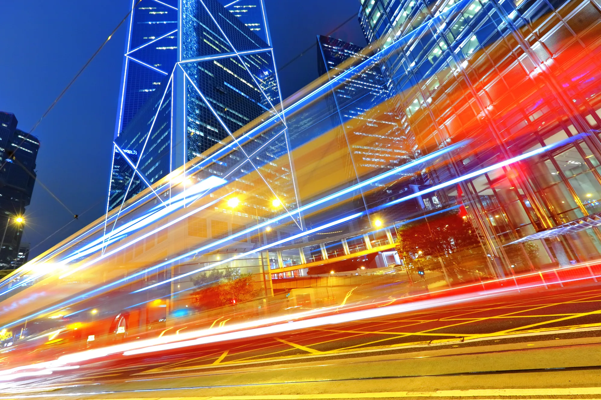 A blurry photo of a city at night with a bright blue sky.